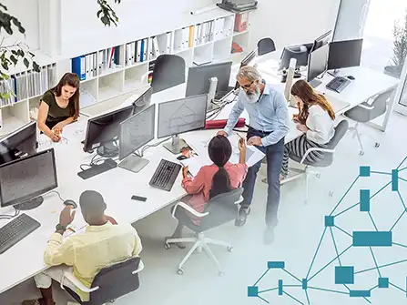 A team collaborating at computer workstations in an open-plan office