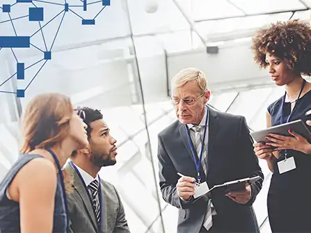 Business leaders in conversation as a colleague takes notes in a modern office