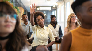 woman raising her hand because she knows the 4 areas of employee engagement