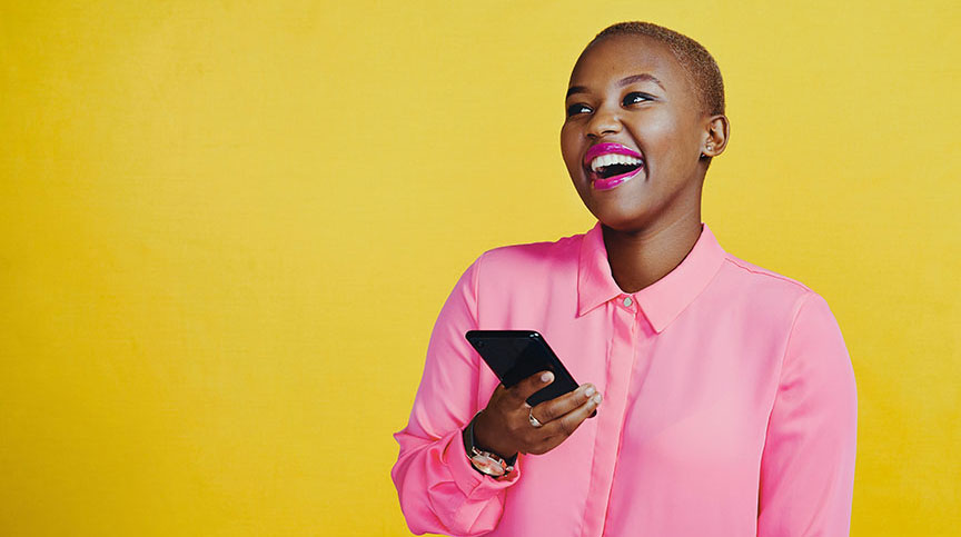 A Black woman holds a smartphone and smiles about the complimentary leadership affirmations calendar and leadership advice from the Center for Creative Leadership